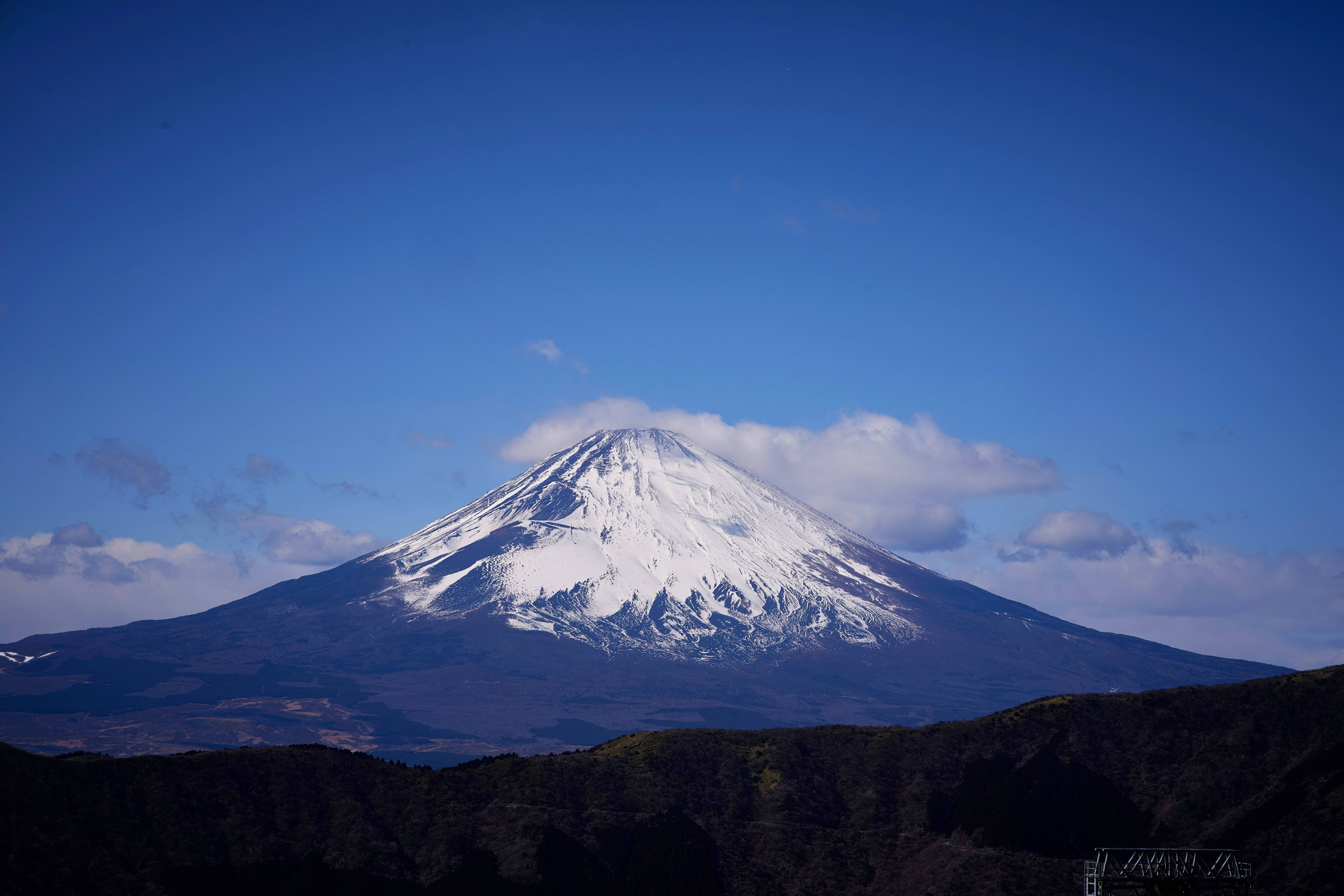 A snow covered mountain in the middle of a blue sky